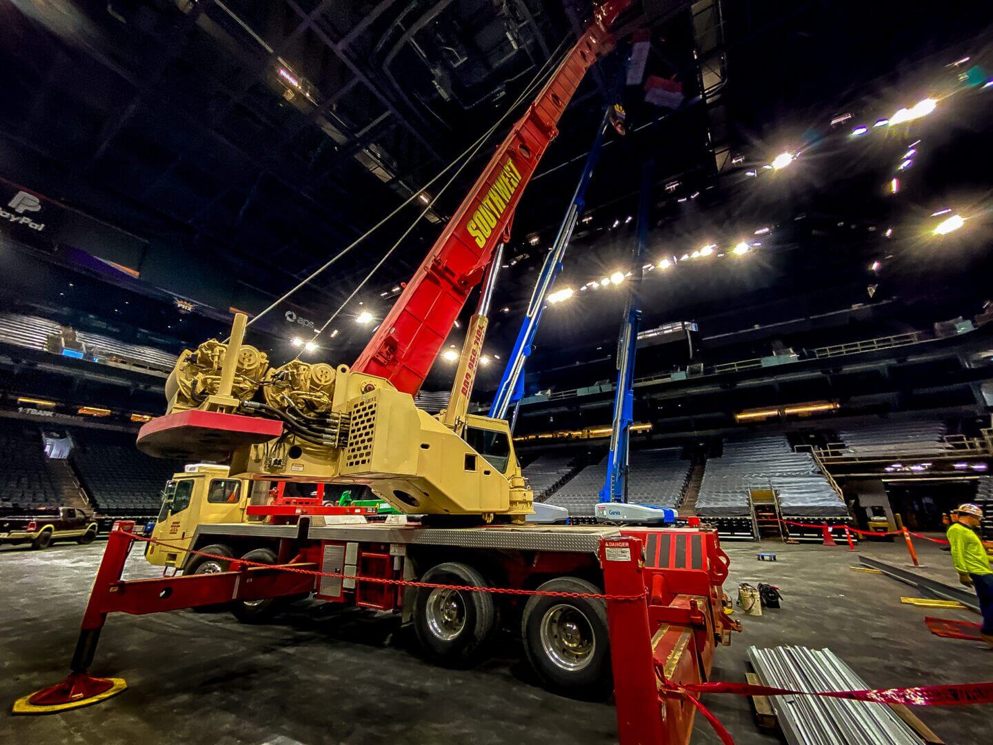 A large red and yellow crane inside a spacious industrial building.